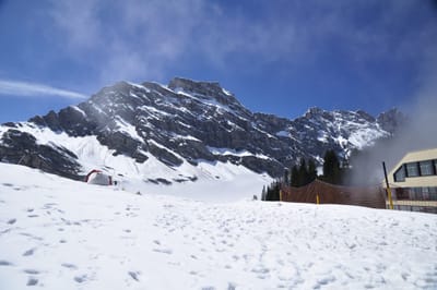 藍天白雲下覆雪的高山峭壁風景