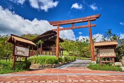 藍天白雲下四重溪溫泉公園的日式鳥居與木造建築