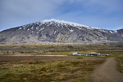 遠眺頂峰覆雪的壯麗火山與停車場風光