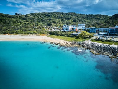 砂島貝殼沙灘的湛藍海岸與聚落風光