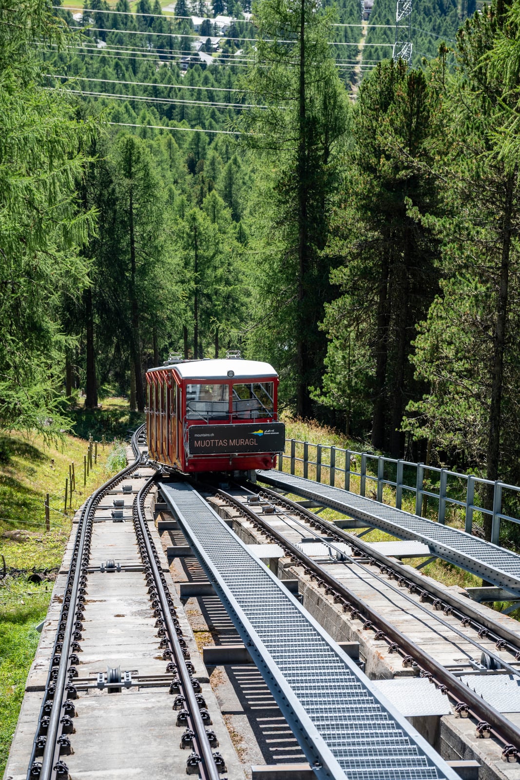 綠意山林間行駛的紅色高山登山纜車｜2024/09 瑞士