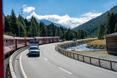 群山環繞的蜿蜒公路與紅色列車