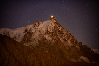 星空下高山雪峰與微光建築