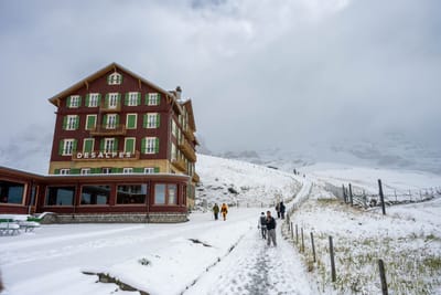 群山環抱中覆雪的山莊建築與健行步道