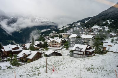 初雪覆蓋的山城屋舍與裊裊雲霧