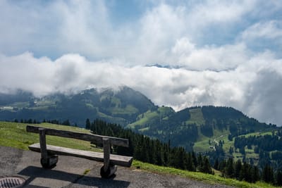 群山雲海環繞的高山木椅與翠綠山坡