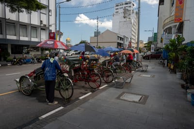 街道旁整齊停靠的人力三輪車