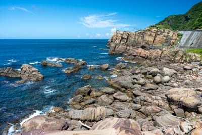 層疊岩石與湛藍海岸的夏日午後