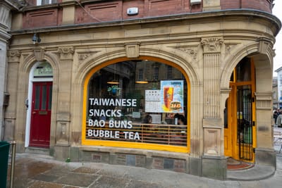 古樸街角販售臺灣小吃與珍奶的餐館外觀