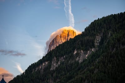 夕陽餘暉映照山巔與斜向雲尾