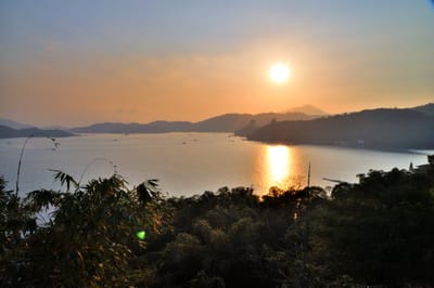 落日餘暉映照湖面與山巒景色