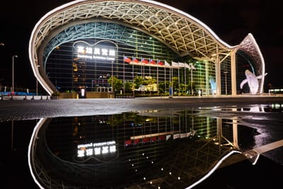 夜色中高雄展覽館的流線外觀與水洼倒影