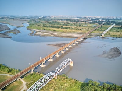 午後陽光下橫跨高屏溪的長長鐵道舊橋